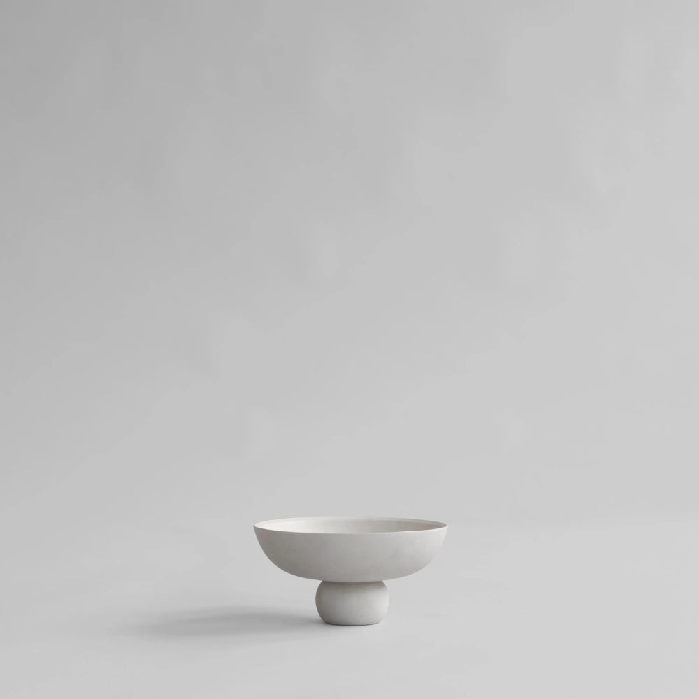 Baburu Bowl Mini by 101 Copenhagen in a soft birch-coloured ceramic finish, featuring a wide, shallow bowl balanced on a small rounded base against a white background.