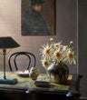 Faux Spider Chrysanthemum in Cream by Fake It Flowers, arranged in a dark ceramic vase on a wooden table in a traditional interior.
