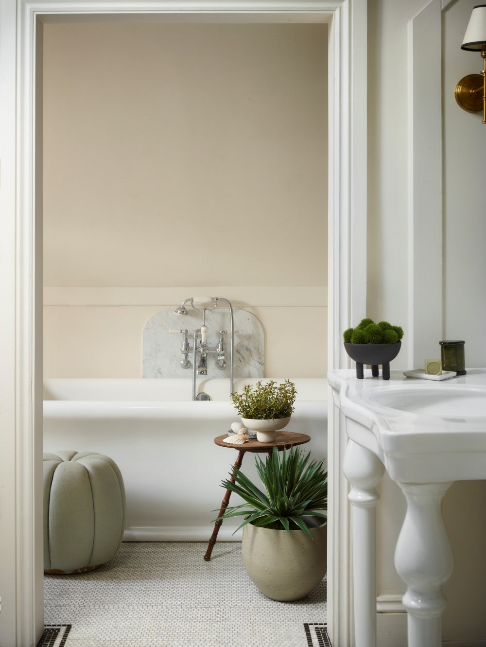 Faux Potted Dianthus in a three legged 101 Copenhagen duck bowl in a bathroom setting with a hyper realistic Agave in Green, featuring long, pointed green leaves with cream edges, displayed in a decorative planter on the floor of a light, elegant interior.