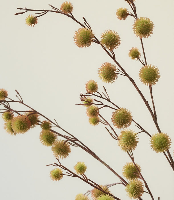 Artificial artificial Chestnut Spray with small spiky yellow-green-brown chestnut casings against a plain light beige background.
