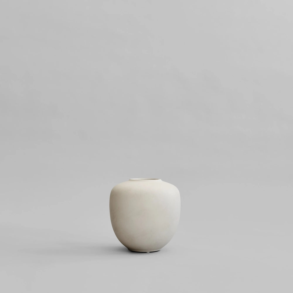 Sunao Vase Mini in Birch by 101 Copenhagen, featuring a softly rounded silhouette, narrow opening and smooth, pale cream ceramic finish, photographed against a neutral background.