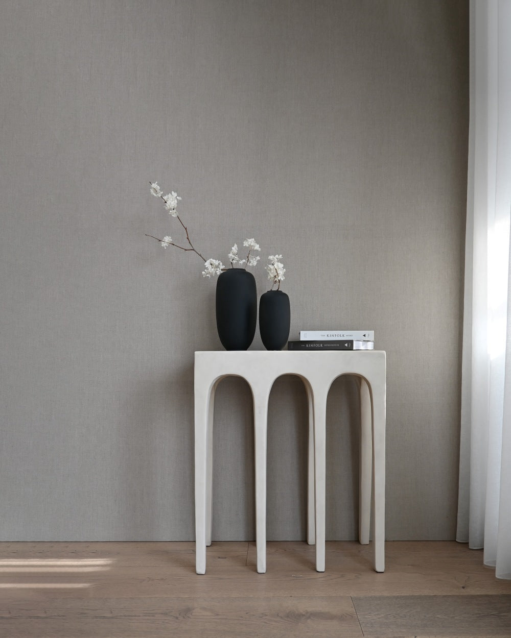 A pair of 101 Copenhagen Sunao Slim vases in black, styled with faux blossom sprays.
